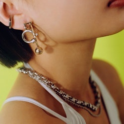 Model wears Justine Clenquet's silver and gold jewelry pieces.
