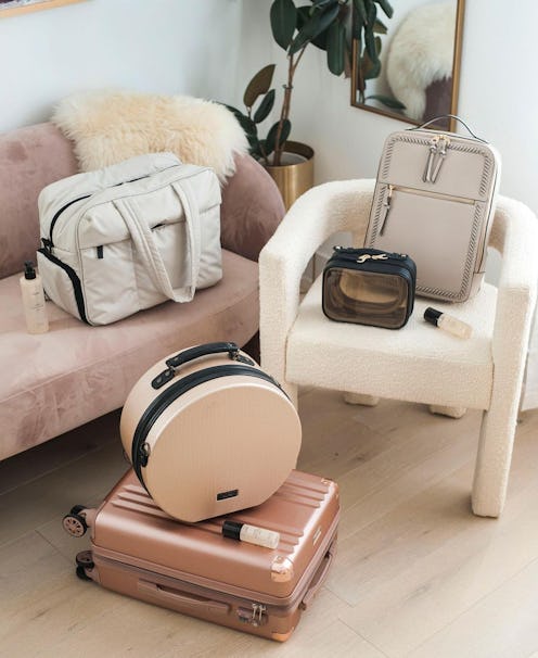 Beige and pastel pieces of luggage on chairs and on a couch