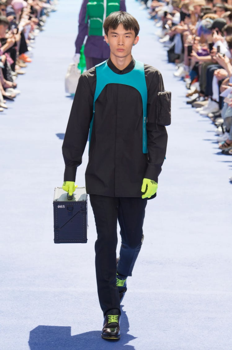 A male model walking in a black jacket at the Louis Vuitton menswear spring 2019 show