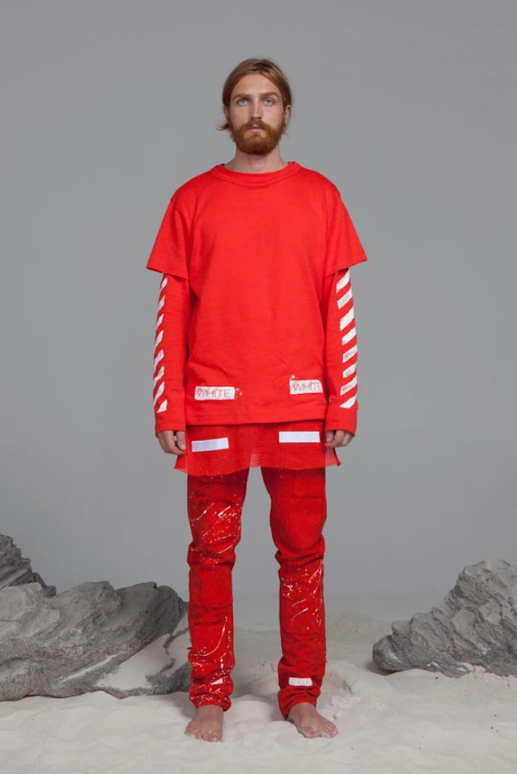 Male model posing in red pants and shirt designed by Abloh   