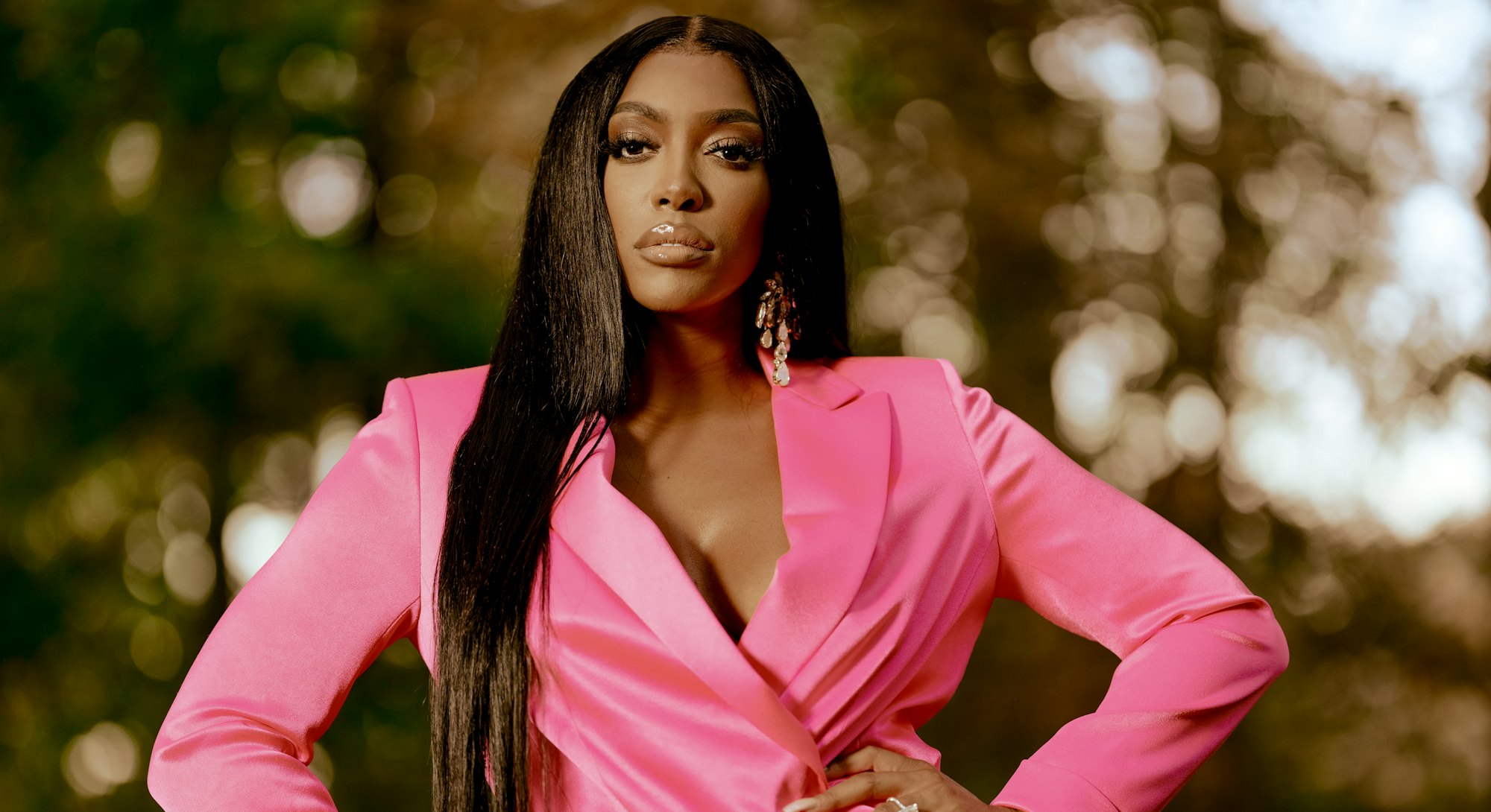 Porsha standing in a pink suit with her hands on her hips