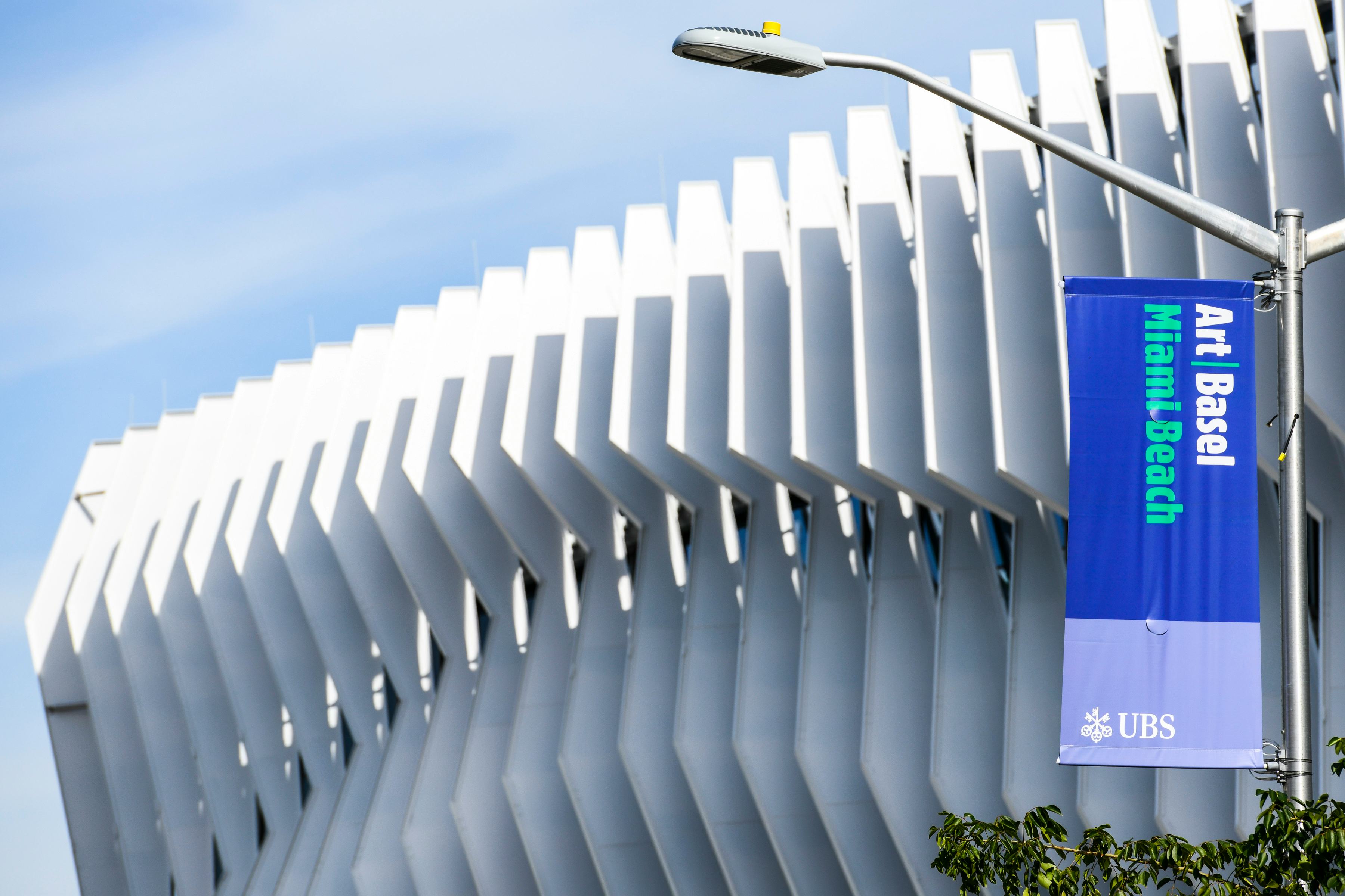 the exterior of the Miami Beach Convention Center, with a flag depicting the logo of the Art Basel M...