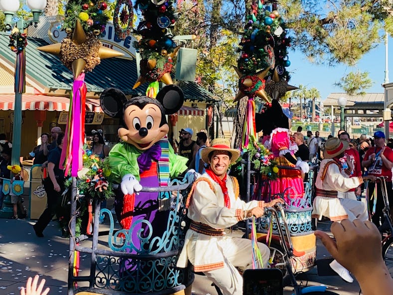 Mickey Mouse rides in a parade at Disneyland during the holidays. 