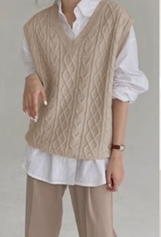This classic cable-knit sweater vest has an oversize fit.