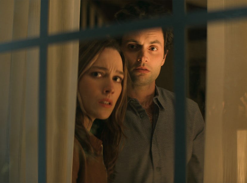Love (Victoria Pedretti) and Joe (Penn Badgley) looking out the window on Netflix's 'You' to show th...