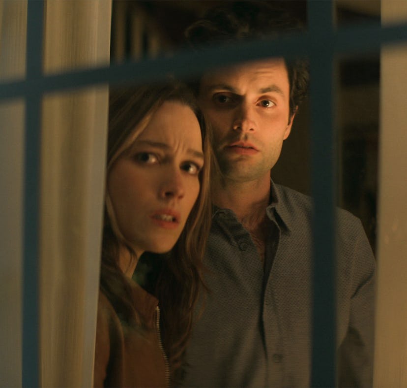Love (Victoria Pedretti) and Joe (Penn Badgley) looking out the window on Netflix's 'You' to show th...