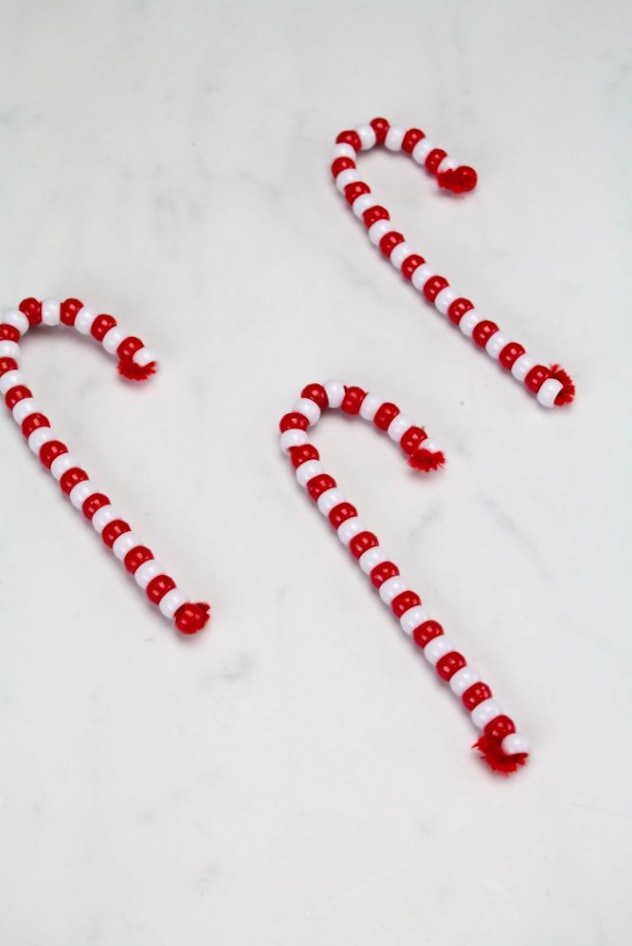 Pipe cleaner DIY candy cane ornaments are easy for kids to make.
