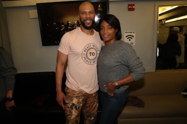 Common in a white shirt and camo pants and Tiffany Haddish in a grey sweater and blue denim jeans