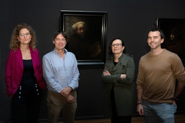 scientists standing in front of a Dutch painting Rembrandt