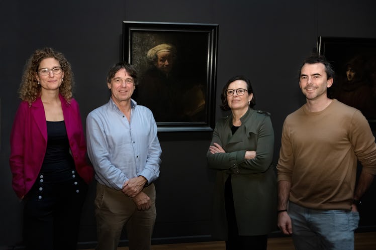 scientists standing in front of a Dutch painting Rembrandt