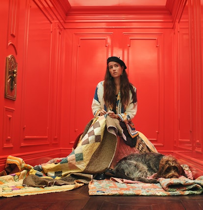 Designer Emily Bode of Bode sitting in a red elevator covered by rugs