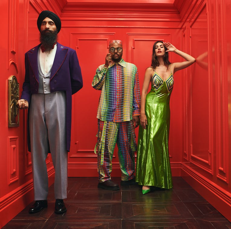 Designer Waris Ahluwalia, Designer Christopher John Rogers, and model Bruna standing in a red elevat...