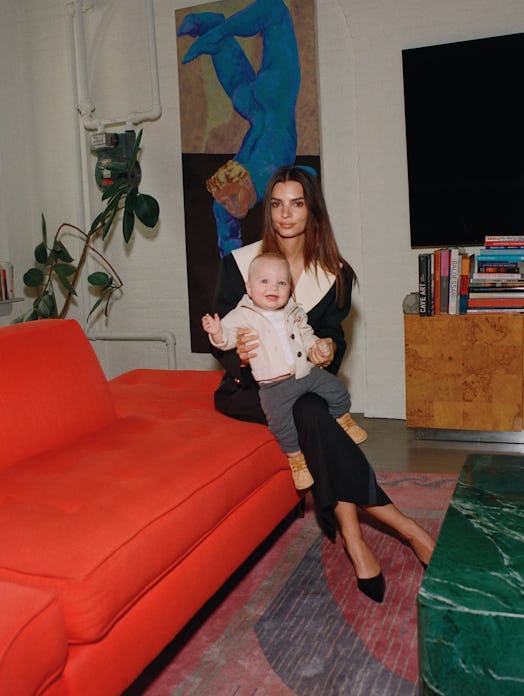 Emily Ratajkowski posing on a couch with her baby.