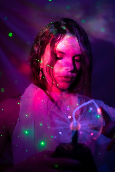 Young woman wrapped in twinkle lights getting ready to fight on Christmas 2021, per her zodiac sign.