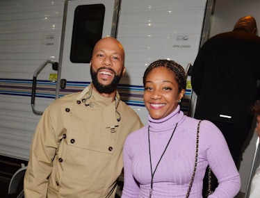 Common in a beige trench coat and Tiffany Haddish in a lavender dress