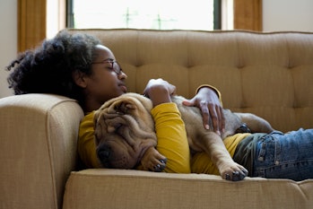A woman cuddles with a dog