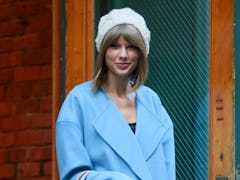 Taylor Swift wearing a hat and blue coat in the winter to show her lyrics were made for winter, snow...
