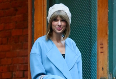 Taylor Swift wearing a hat and blue coat in the winter to show her lyrics were made for winter, snow...