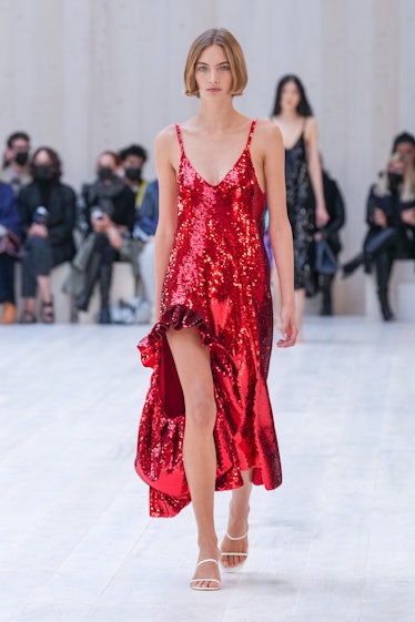   یک مدل در طول نمایش لباس زنانه Loewe بهار/تابستان 2022 روی باند فرودگاه راه می‌رود