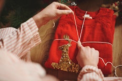 Woman wrapping Christmas jumper with twine
