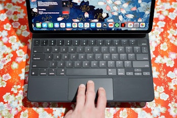 Three fingers swiping on the trackpad of Apple's Magic Keyboard on an iPad Pro.