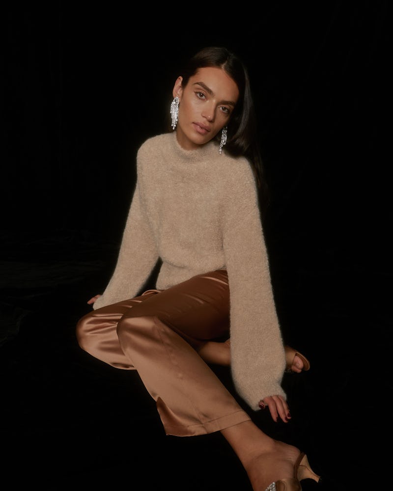 Model wears outfit from Reformation's Cozy at Home Holiday Collection.