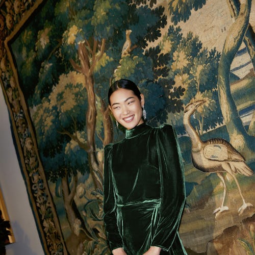 Model wears green high-neck dress from Reformation's Holiday collection.