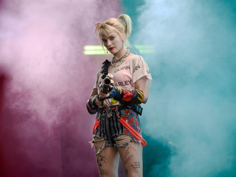 Margot Robbie as Harley Quinn in Birds of Prey holding a gun in a pink-blue smoke environment