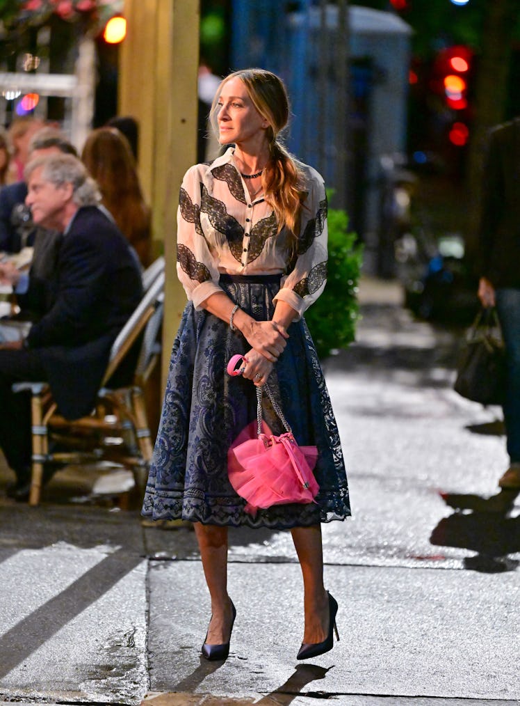 Carrie wearing a blouse and skirt with pink bag