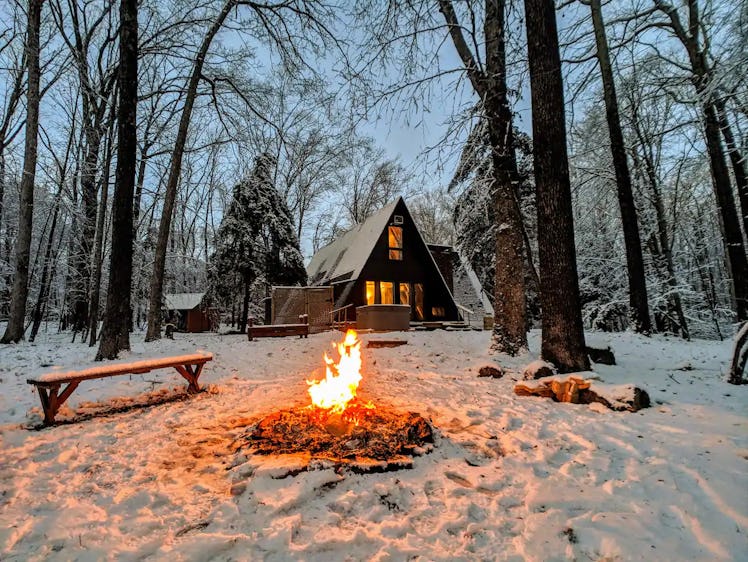 This Christmas cabin on Airbnb has a hot tub and fire pit outside.