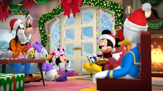 Mickey Mouse wears a Santa hat while reading a book to Minnie Mouse, Donald Duck, Daisy Duck, and Go...