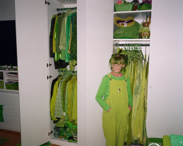 Elizabeth Sweetheart wears her own hand-dyed overalls and shirt uniform standing in front of a close...