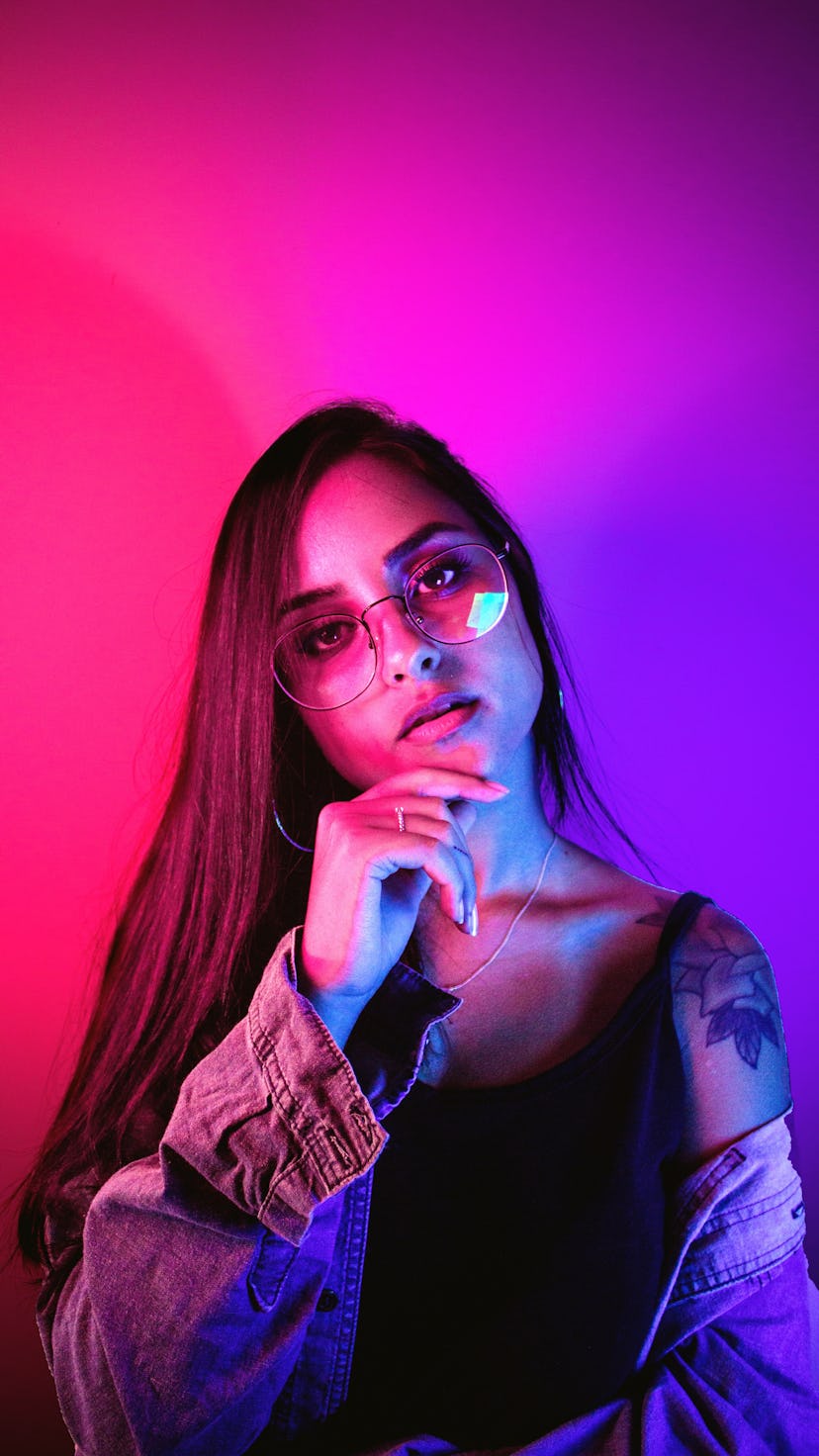 Young woman in pink and purple neon lights, getting ready to fight on New Year's Eve 2021, per her z...