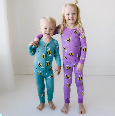 Little boy and girl standing together, modeling PJs with bumble bees on them