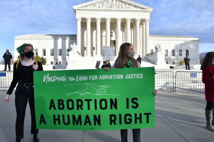 Participants hold a sign that says "Abortion is a human right" s at the Women's March "Hold The Line...