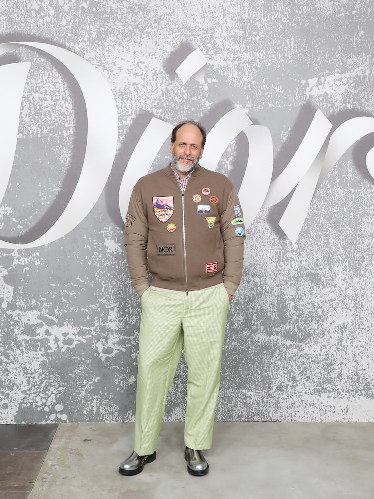 Luca Guadagnino in a dark green bomber jacket and light green pants at  Dior Men’s Fall 2022
