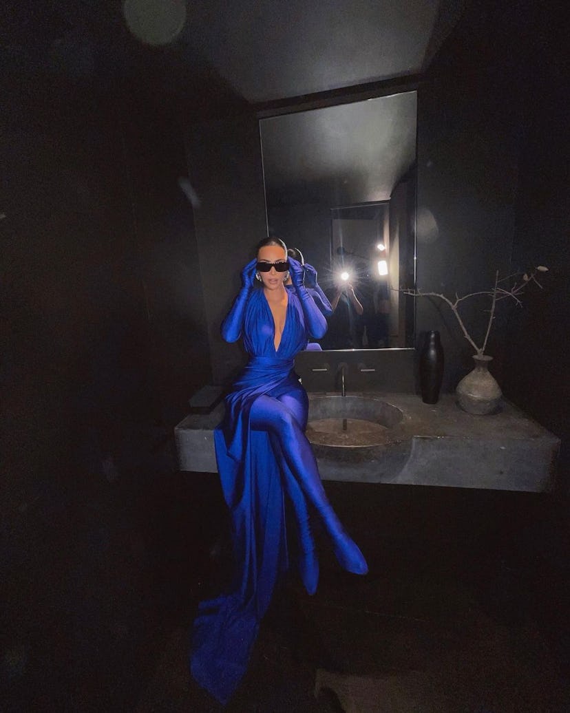 Kim Kardashian wearing sunglasses and a blue ensemble by Balenciaga