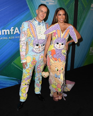 Jeremy Scott and Anitta wearing outfits with cartoon motives, while Anitta is carrying a heart-shape...