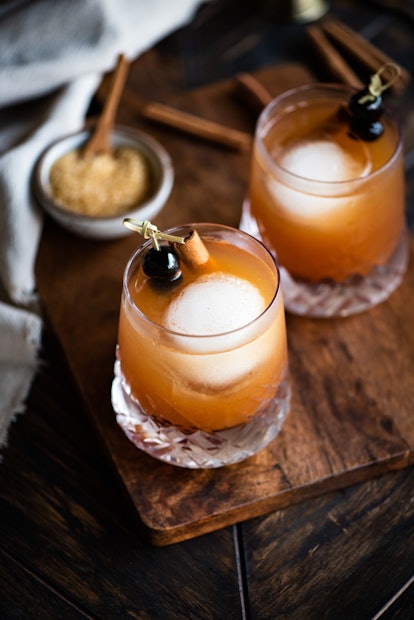 Two apple whiskey cocktails sitting on wood table