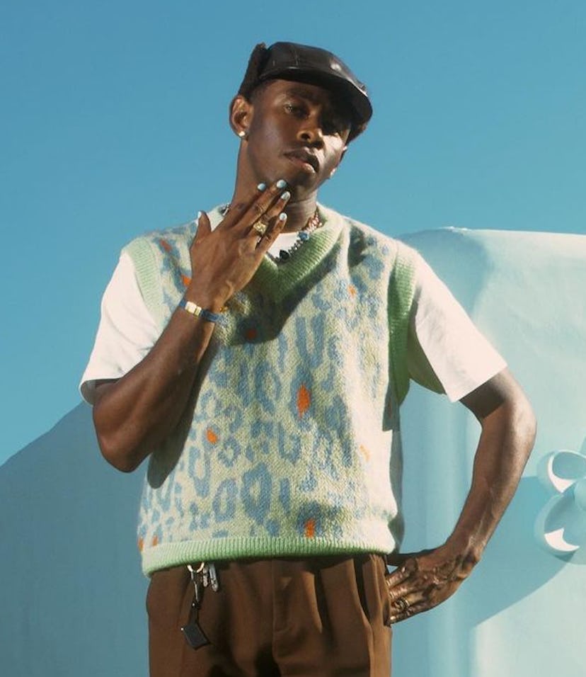 Tyler The Creator in front of store with blue nails posed
