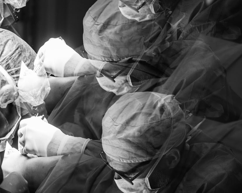 Black and white photo of a doctor delivering a baby via cesarean 