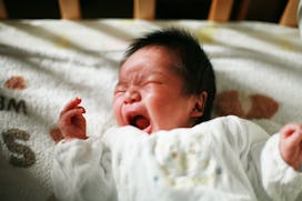 Baby lying in its crib and crying