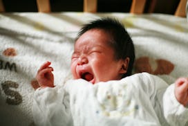 Baby lying in its crib and crying