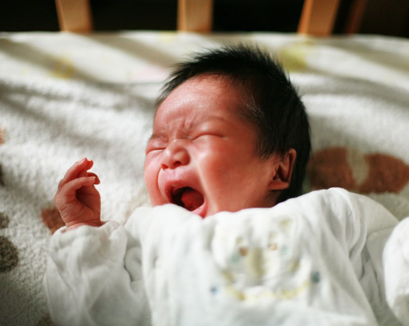 Baby lying in its crib and crying