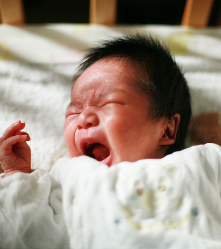 Baby lying in its crib and crying