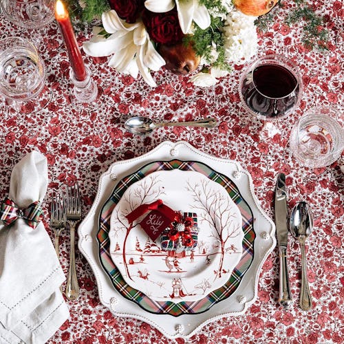 A decorative holiday plate on a patterned holiday tablecloth with other holiday details