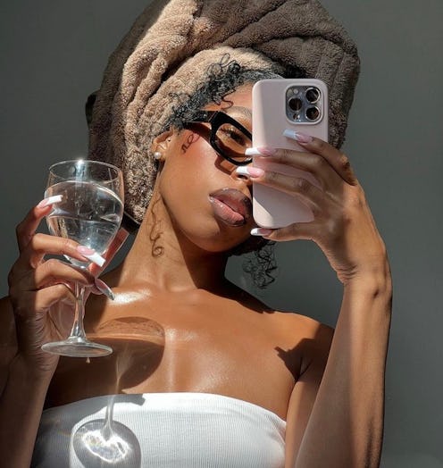 woman wearing a towel and drinking wine