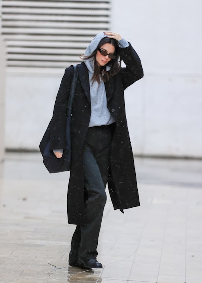 Kendall Jenner wears a gray hoodie and black coat in 2021.