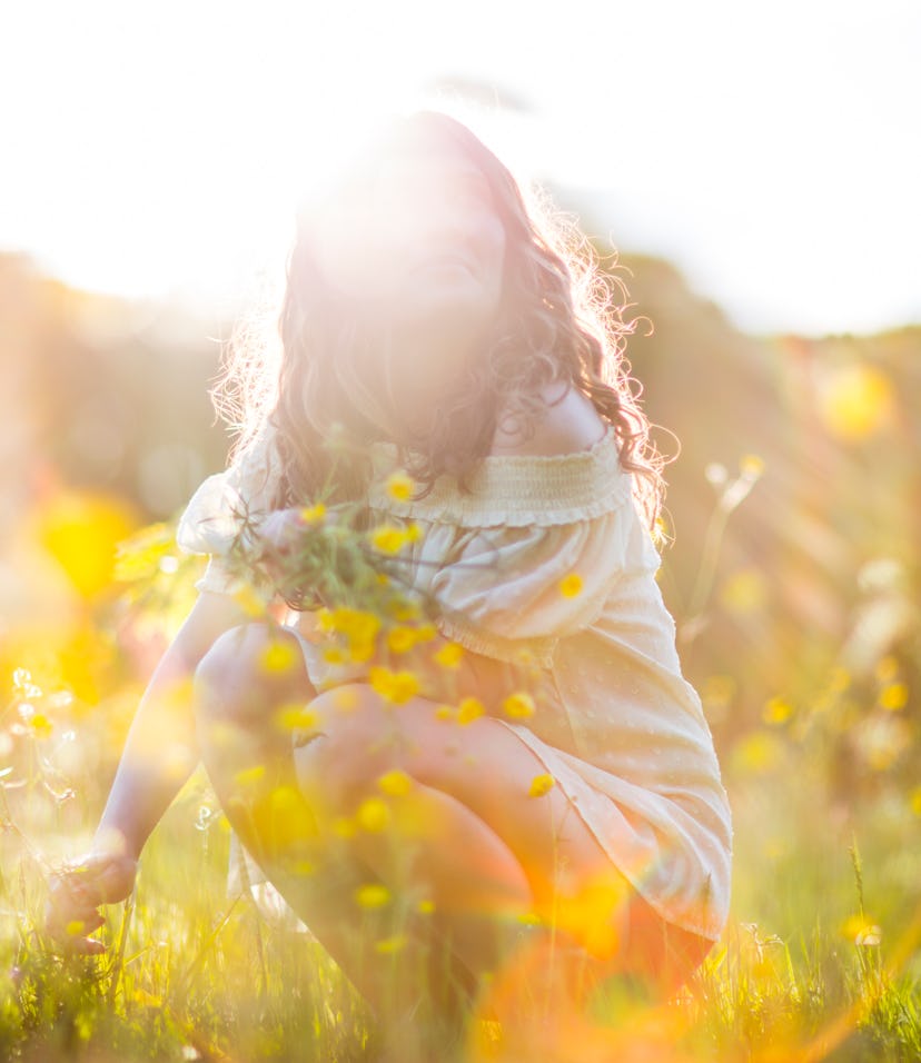 out of focus woman in a field of yellow flowers