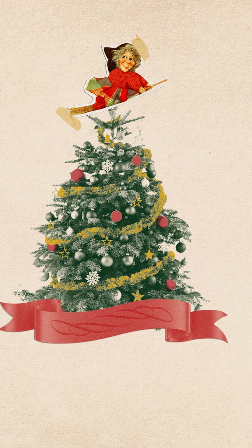 A decorated christmas tree with a christmas witch cutout placed at the top